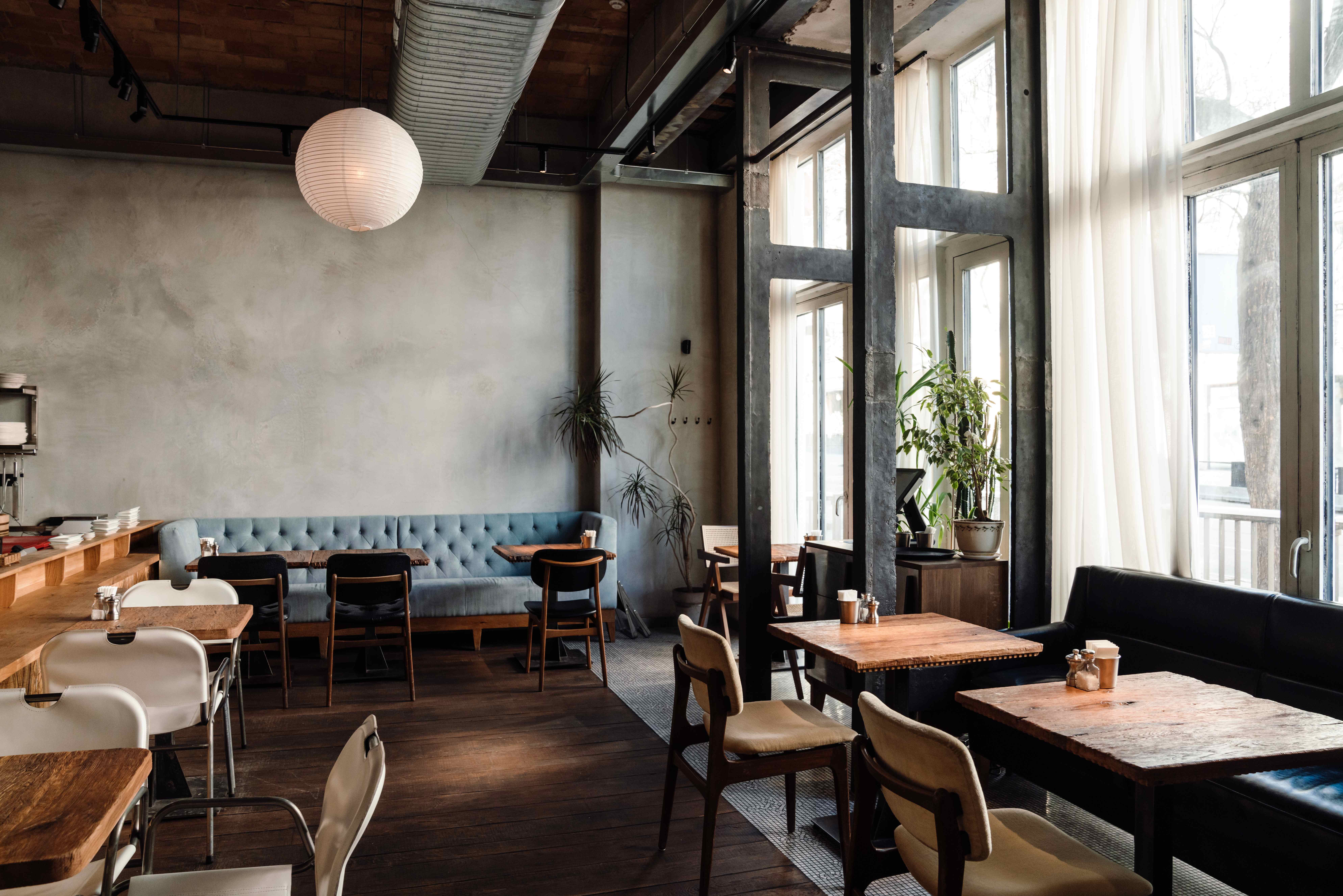 A stylish industrial-chic bar interior with velvet seating