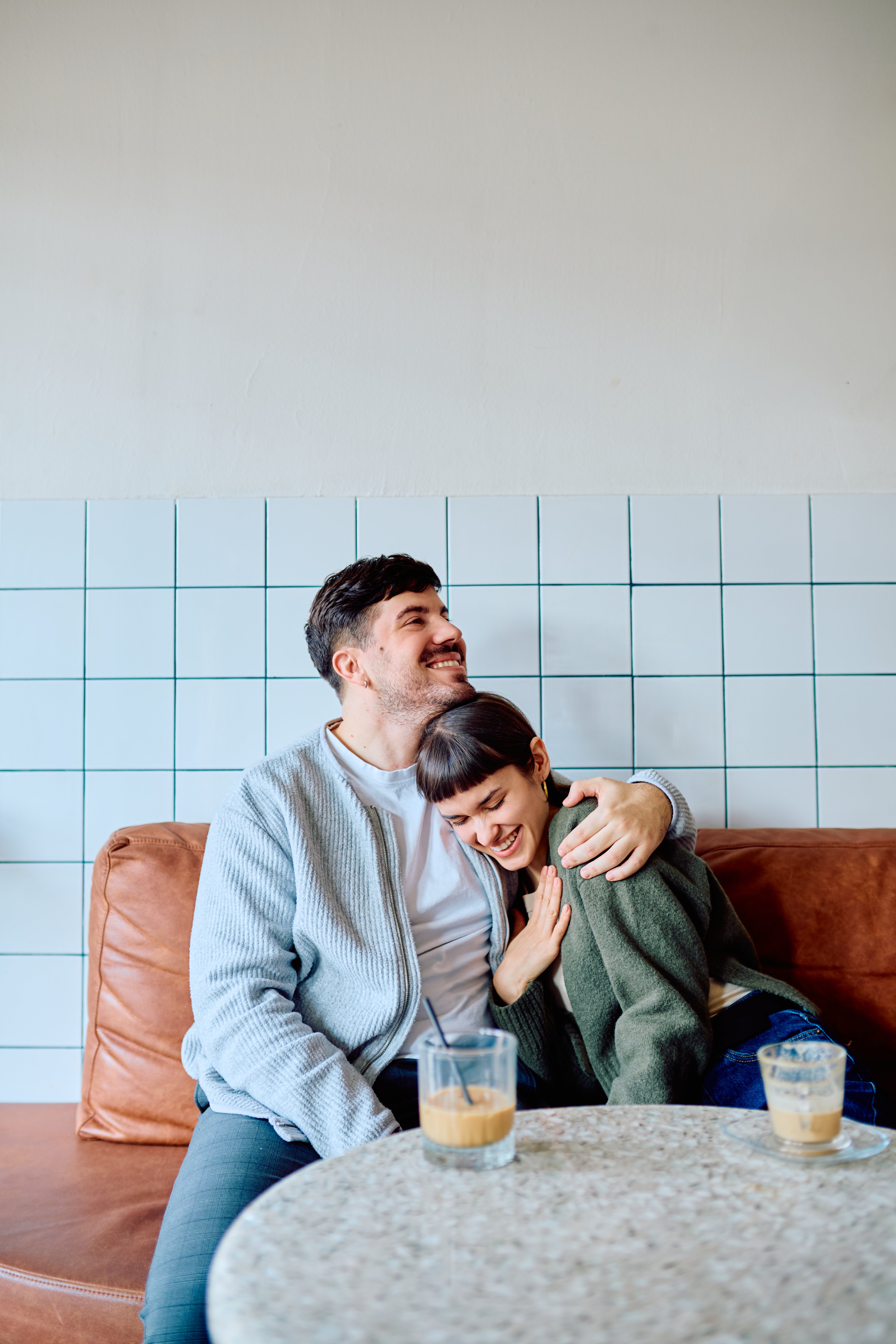 A couple laughing together over coffee at a local cafe